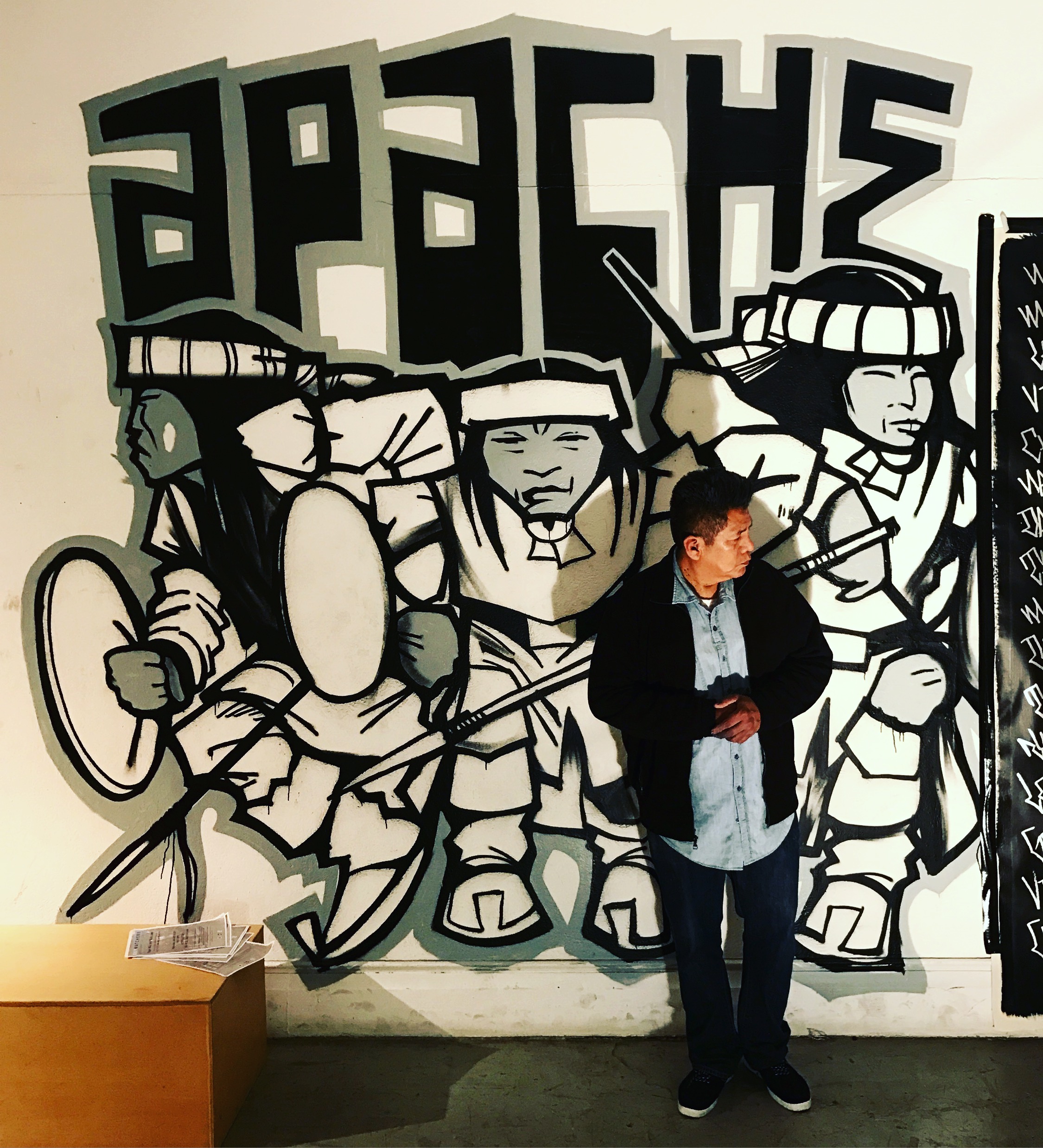 Douglas Miles in front of his APACHE mural